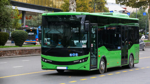 A Green Bus On A City Street